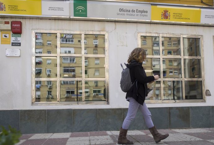 Archivo - Una mujer sale de una oficina de empleo en Sevilla, en una foto de archivo.