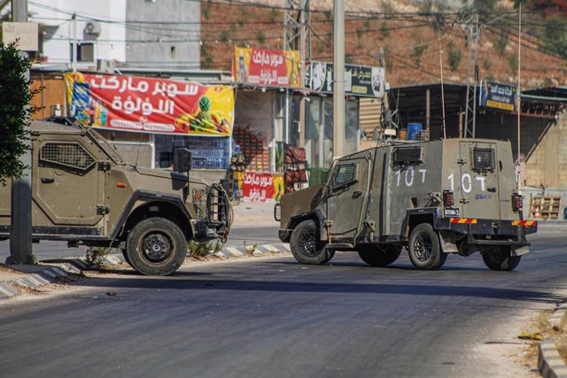 01 September 2023, Palestinian Territories, Nablus: Israeli military vehicles surround a house containing wanted armed Palestinians during a raid to arrest them in the village of Aqaba. Photo: Nasser Ishtayeh/SOPA Images via ZUMA Press Wire/dpa