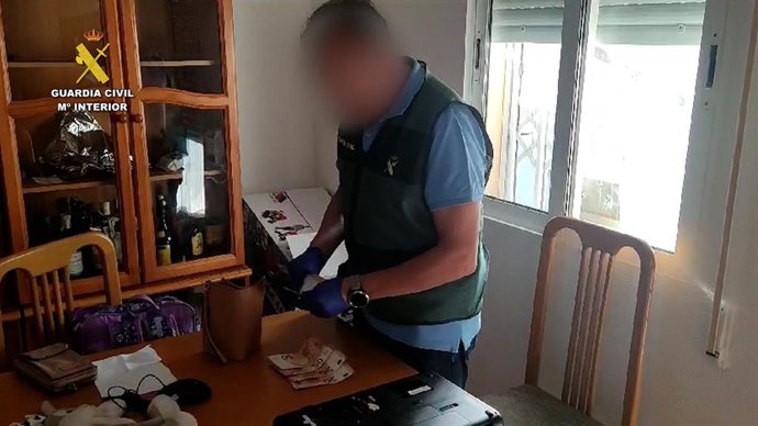 Un agente de la Guardia Civil en uno de los pisos registrados en el marco de la la operación 'Fulcom',  que se ha saldado con la detención de tres personas como presuntas autoras de los delitos de tráfico de seres humanos y estafa, entre otros