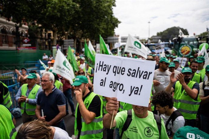 Archivo - Un hombre con un cartel en el que se lee: 'Hay que salvar al agro ya!', durante una tractorada convocada por la Unión de Uniones de Agricultores y Ganaderos, frente al Ministerio de Agricultura, a 5 de julio de 2023, en Madrid (España). La pro
