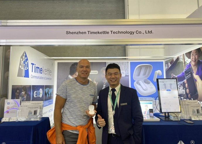 The visitor tests translator earbuds at Timekettle booth.