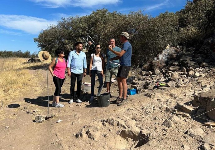 El alcalde de Peñarroya (2 izda.) atiende a las explicaciones del arqueólogo que dirige la excavación del Peñón, junto a los restos hallados, del periodo Calcolítico.