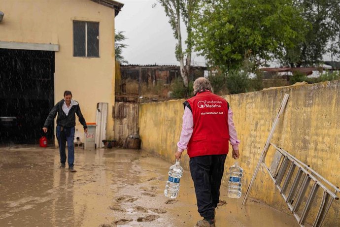 Voluntarios de la Fundación Madrina llevan agua a la Cañada Real tras el paso de la DANA.