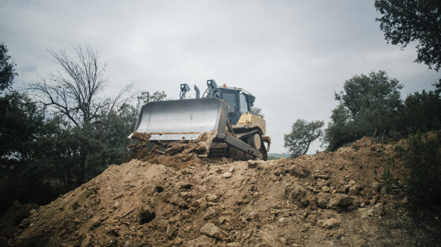 Varias personas y camiones junto a la tubería del embalse de Picadas el día que comienza su reparación, a 7 de septiembre de 2023, en Aldea del Fresno, Madrid (España). 