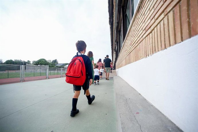 Archivo - Unos niños entrando al colegio.