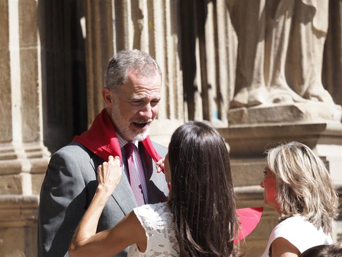 La Reina Doña Letizia anuda un pañuelo rojo de Sanfemrines al Rey Don Felipe en su visita a la Casa Consistorial de Pamplona.