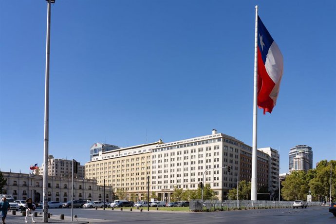 Archivo - March 2, 2023, Santiago, Santiago Metropolitan Region, Chile: Huge Chilean flag in front of the La Moneda Palace, left, and the Banco Estado building in downtown Santiago, Chile.