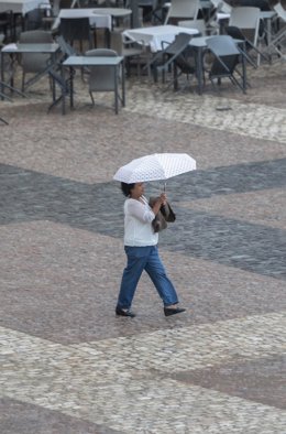 Una persona se protege de la lluvia con un paragüas