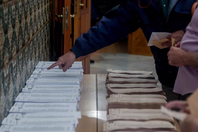 Archivo - Una persona coge papeletas para votar en un colegio electoral, en Madrid, el pasado 28M