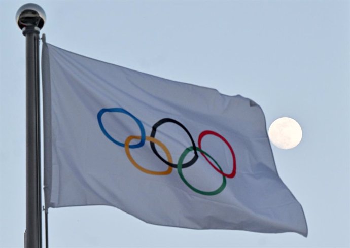 Archivo - FILED - 14 February 2022, China, Beijing: The moon can be seen behind the flag with the Olympic rings. Ukrainian athletes have been given permission by their sports ministry to compete against Russians and Belarusians at international sports e