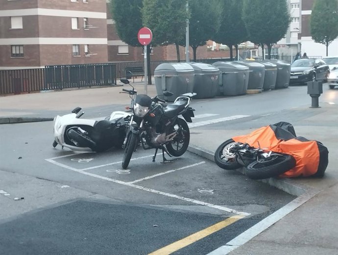 Motos tiradas en el suelo a causa del temporal en la calle Poeta Alfonso Camín, en Gijón.