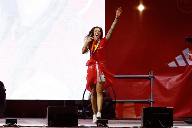 Jenni Hermoso posa en el césped con sus obsequios del Pachuca por ganar el Mundial y el tifo en su  honor al fondo