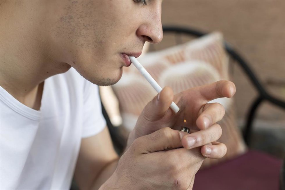 Joven adolescente encendiendo un cigarrillo, en imagen de archivo