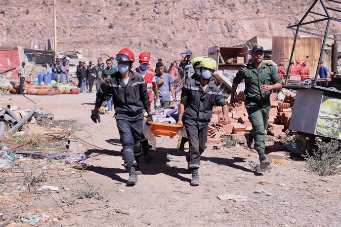 Militares marroquíes y Protección Civil de Marruecos llevan a un hombre fallecido tras ser rescatado de entre los escombros