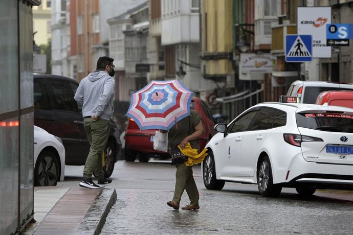 Archivo - Una mujer se resguarda del viento y la lluvia con un paraguas en el centro de la ciudad, a 19 de junio de 2022, en A Coruña, Galicia, (España). La inestabilidad se mantendrá en Galicia al menos hasta la mitad de la semana que viene. A partir d