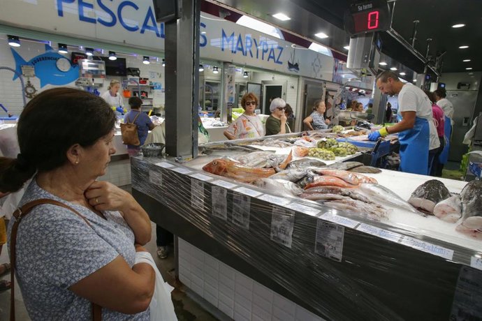 Archivo - Una persona compra alimentos en un mercado.