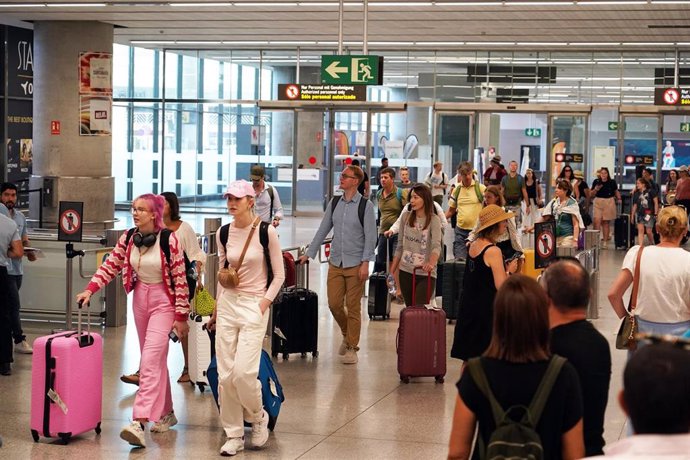 Archivo - Imagen de archivo de cientos de personas a su llegada al aeropuerto de Málaga Costa del Sol en pleno verano.