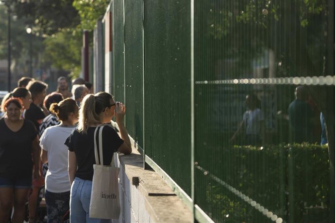 Padres y madres en la entrada de un colegio