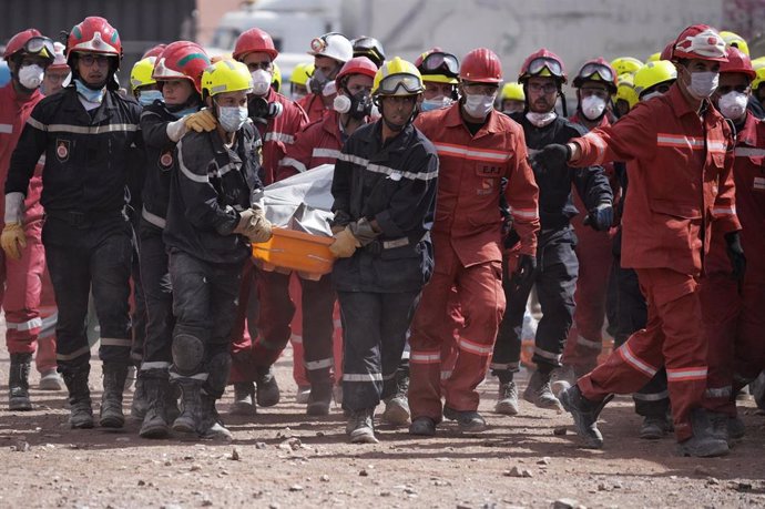 Un grupo de bomberos lleva el cuerpo de una persona fallecida por el terremoto en Talat N'Yaaqoub, provincia de Al Haouz