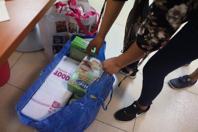 Archivo - Una voluntaria prepara una bolsa para repartir en la Fundación Red Madre, que proporciona ayuda a mujeres embarazadas y madres recientes afectadas por la pandemia del coronavirus dentro de la campaña de donación SOS Becas Mamá, en Las Rozas, M