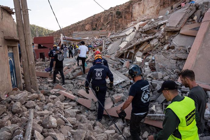 Varios bomberos de la ONG BUSF caminan por una zona destruida por el terremoto, a 12 de septiembre de 2023, en Imi NTala (Marruecos). (Foto de archivo).