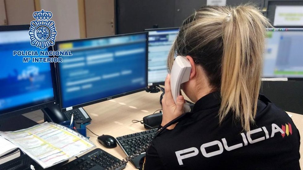 Archivo - Un agente de Policía Nacional atiende una llamada