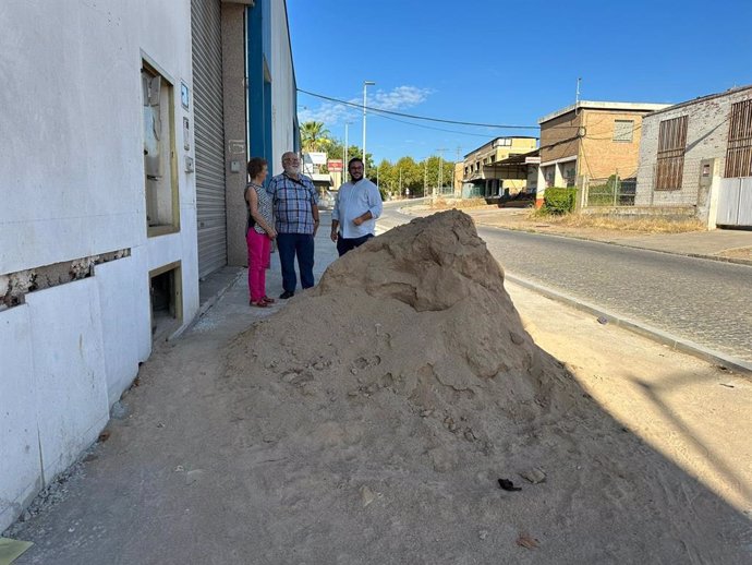 Ediles de Hacemos Córdoba ante uno de los montones de arena que obstaculizan el paso en la calle Sor Ángela de la Cruz.
