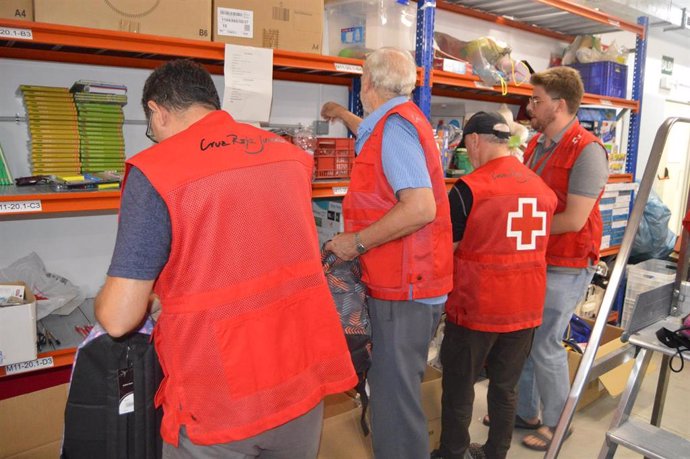 Voluntarios de Cruz Roja preparan los lotes de material escolar.