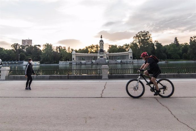 Archivo - Un hombre monta en bicicleta por la calle Nicaragua junto al Estanque en el Parque del Retiro de Madrid