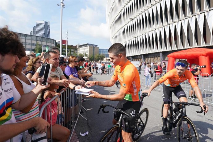 Archivo - Un ciclista firma un autógrafo a un hombre durante la salida de la sexta etapa de La Vuelta Ciclista a España 2022, desde el estadio de San Mamés, a 25 de agosto de 2022, en Bilbao, Euskadi (España). En La Vuelta 2022 participan un total de 18
