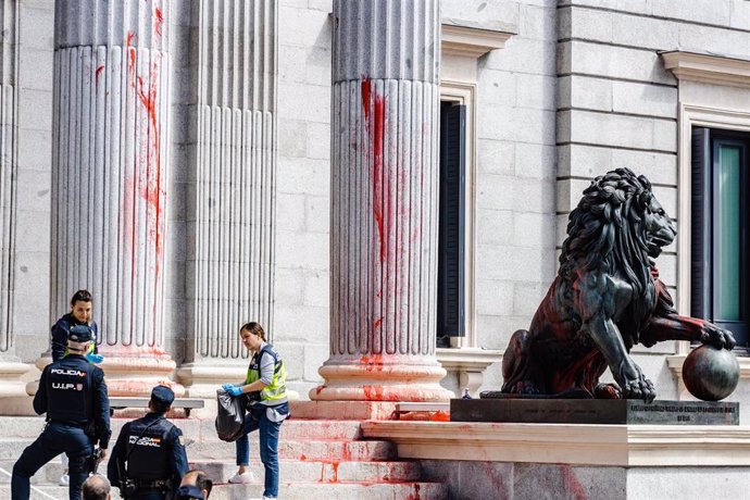 Archivo - Dos mujeres del departamento de Policía Científica de la Policía Nacional y dos agentes del cuerpo en las escalinatas del Congreso de los Diputados tras ser teñidas con pintura roja por activistas de Futuro Vegetal y Rebelión Científica, a 30 