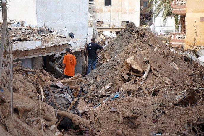 DERNA, Sept. 17, 2023  -- This photo taken on Sept. 16, 2023 shows people standing amid debris in Derna, Libya. On Sept. 10, Mediterranean storm Daniel made landfall in Libya, bringing heavy storms and flash floods along its path in the northeast of the