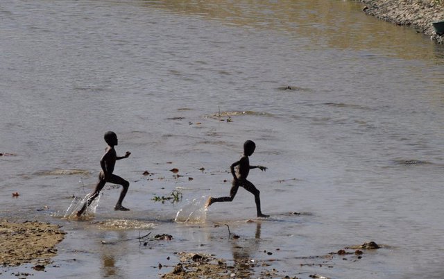 Archivo - Niños haitianos jugando en el río Masacre, en la frontera con República Dominicana