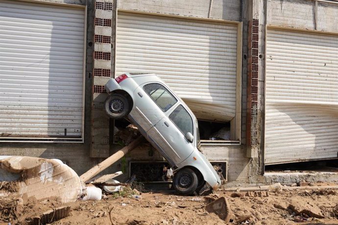 Un vehículo semivolcado en una calle de Derna tras las inundaciones