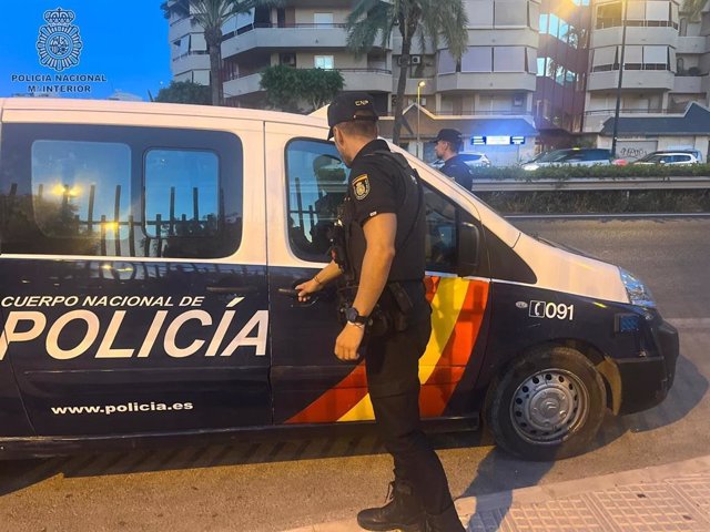 Agentes de la Policía Nacional, en Palma, junto a un vehículo policial.