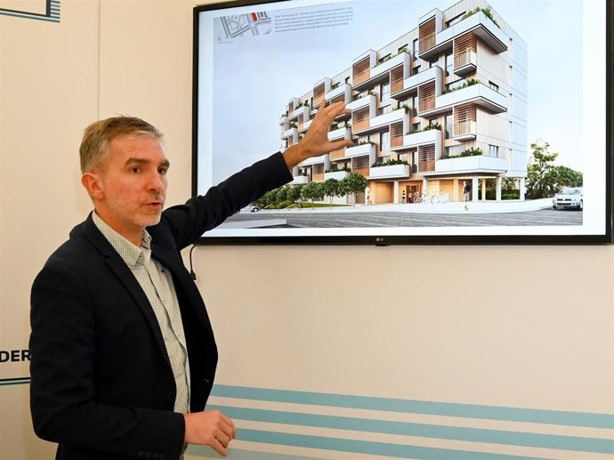 El concejal César Díaz junto a una infografía de las futuras VPO en El Alisal