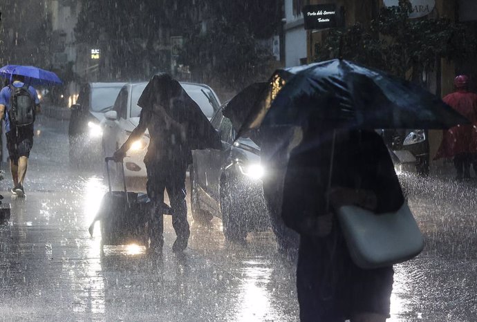 Varias personas con paraguas bajo la lluvia, a 15 de septiembre de 2023, en Valncia, Comunidad Valenciana (España). Las tormentas, en algunos casos de intensidad fuerte, están recorriendo durante las primeras horas de la mañana de este viernes los lito