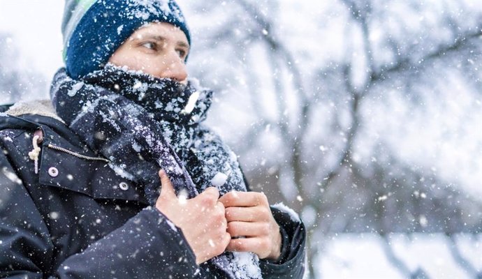 Archivo - Hombre abrigado con frío bajo la nieve.