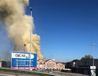 Bomberos trabajan en la extinción de un incendio en dos naves del Polígono Águila del Nora, en Colloto