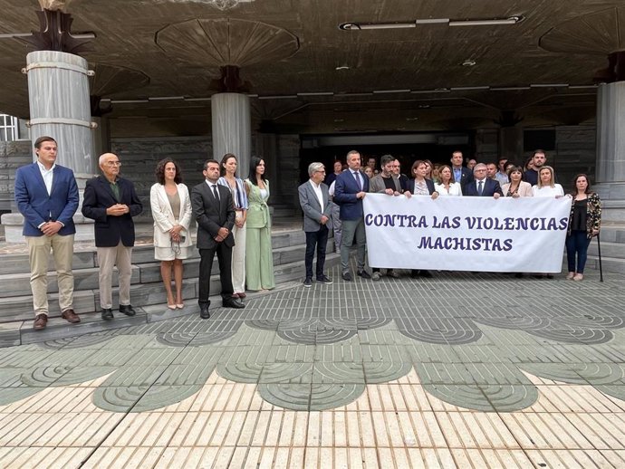 Miembros de la Mesa de la Cámara, portavoces, diputados y personal de la Asamblea Regional se concentran en la puerta principal de la sede parlamentaria para guardar un minuto de silencio por el asesinato de una mujer en Cieza a manos de su expareja