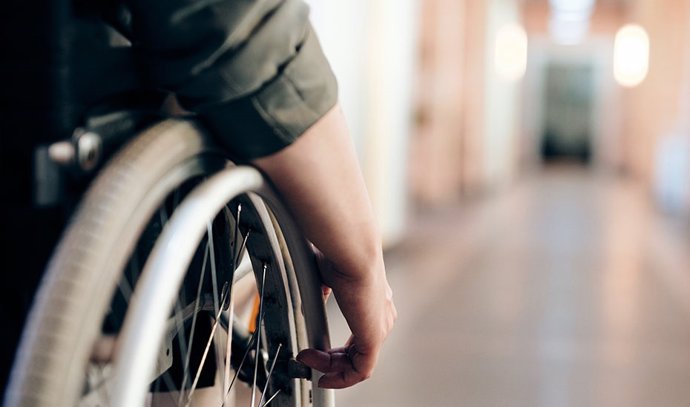 Archivo - Imagen de recurso de una persona en silla de ruedas por el interior de un edificio.