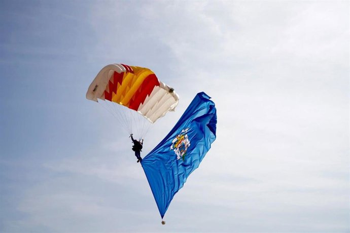 Un paracaidista con las banderas de Melilla y España desciende a la playa melillense en los actos de españolidad de la Ciudad Autónoma