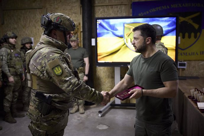 El presidente ucraniano, Volodimir Zelenski, entrega un reconocimiento a un soldado en Bajmut.