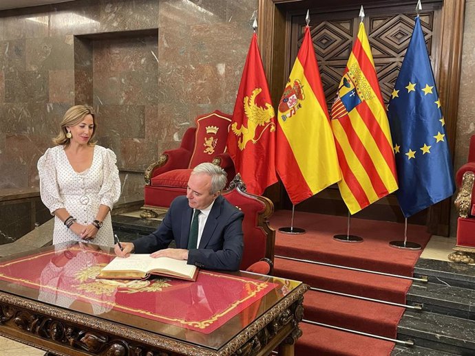 El presidente del Gobierno de Aragón, Jorge Azcón, firma en el Libro de Honor del Ayuntamiento de Zaragoza ante la alcaldesa, Natalia Chueca.