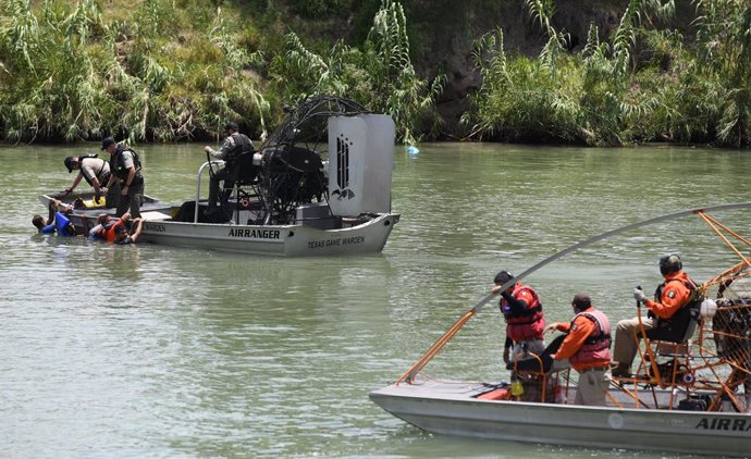 Archivo - 15 July 2022, US, Eagle Pass: Border Patrol agents detain four migrants attempting to reach American soil as members of the Mexican team Grupo Alpha watch from a distance. Hundreds of migrants arrive at the US-Mexico border in Eagle Pass, Texa