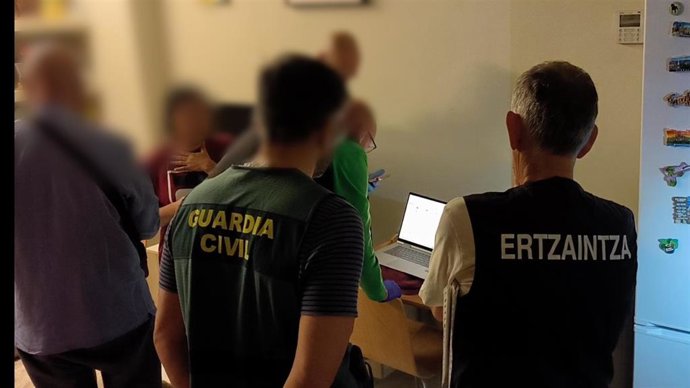 Agentes de Guardia Civil y Ertzaintza en un operativo conjunto en Sevilla por estafa informática
