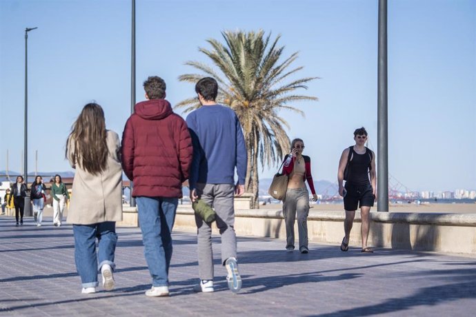Archivo - Un grupo de personas pasea por el puerto de la playa de la Malvarrosa