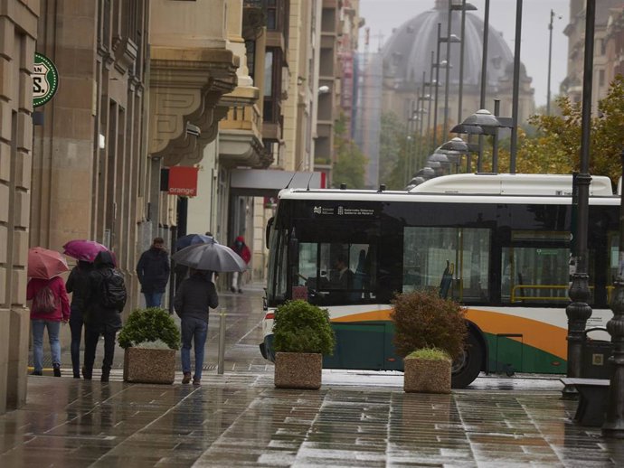 Archivo - Transeúntes caminan protegidos con paraguas.