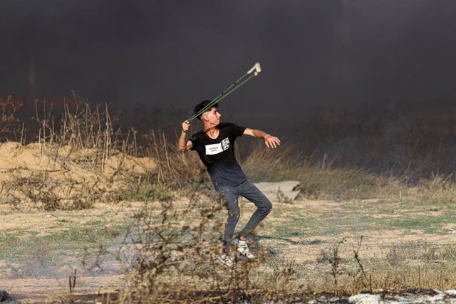 Un palestino lanza una piedra con una honda en Gaza