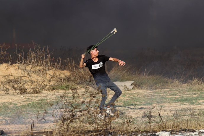 GAZA-ISRAEL BORDER, Sept. 22, 2023  -- A Palestinian protester uses a slingshot to hurl a stone at Israeli soldiers during clashes near the fence of the Gaza-Israel border east of Gaza City, on Sept. 22, 2023. Earlier on Friday, clashes between Palestin